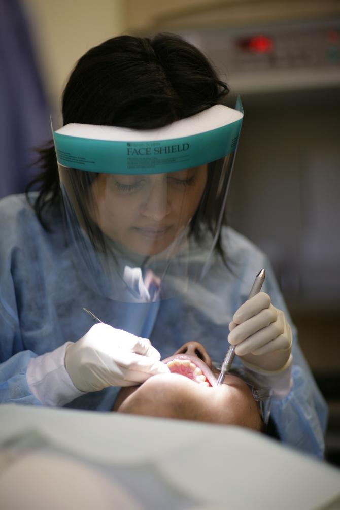A staff dentist performing an exam