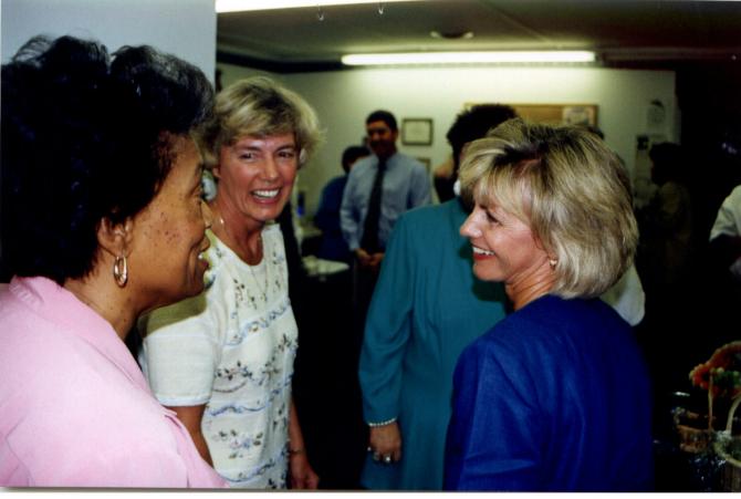 Two women staff members chatting with E. Clayton