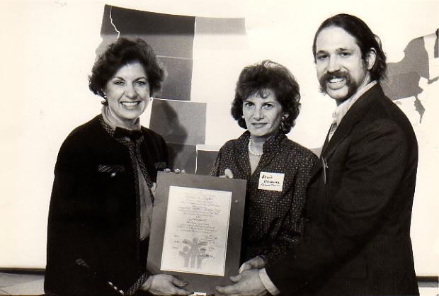 Mark Masselli with two woman showing an award