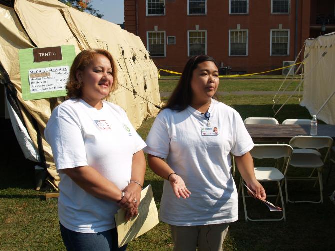 Two women speak with the crowd