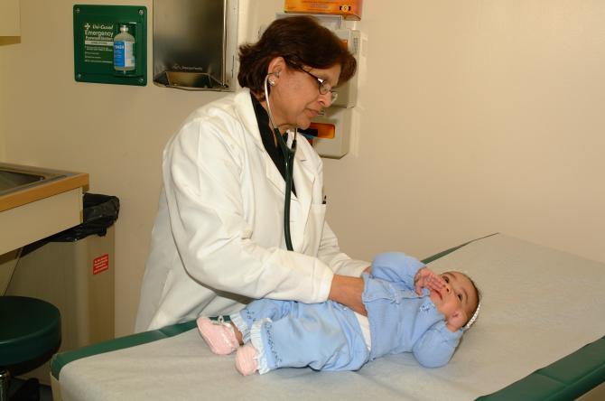A doctor examines a baby girl