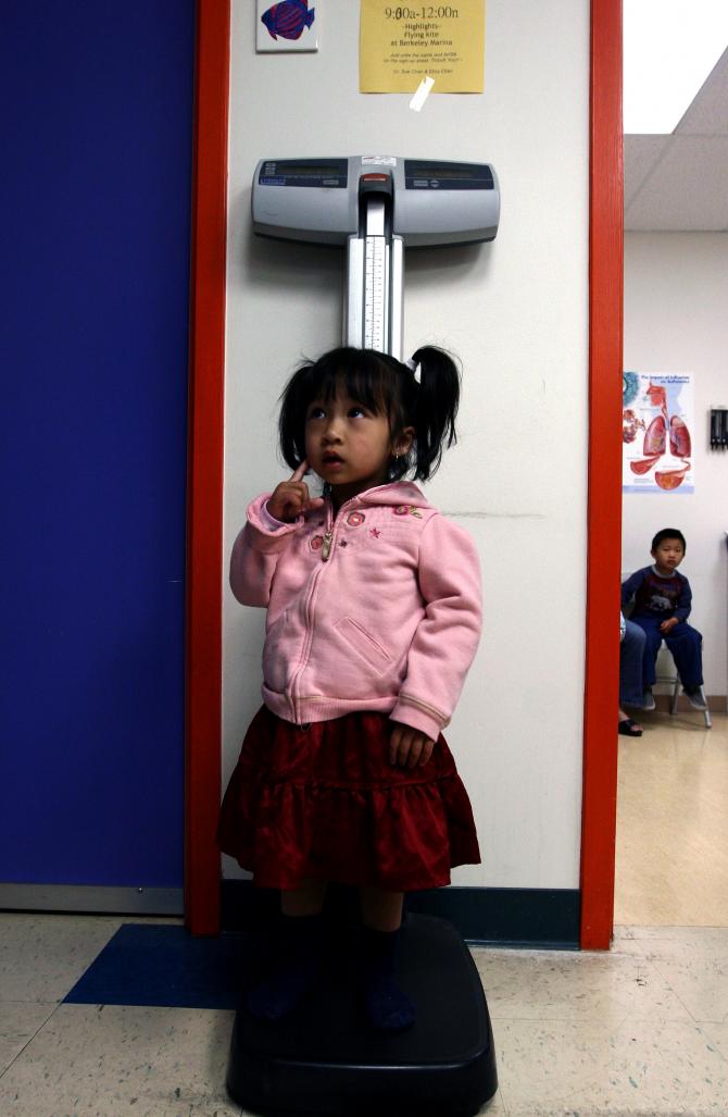 A young girl being weighed