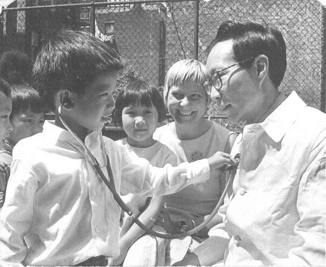 Dr. John Li and young patient at a street fair