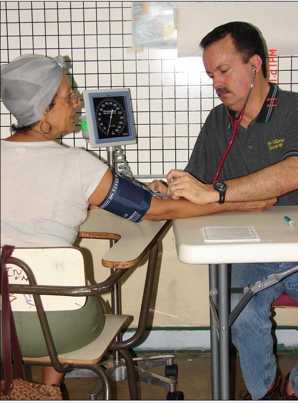 A staff member checks a patient's blood pressure