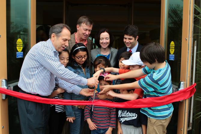 Cutting the ribbon outside the new building